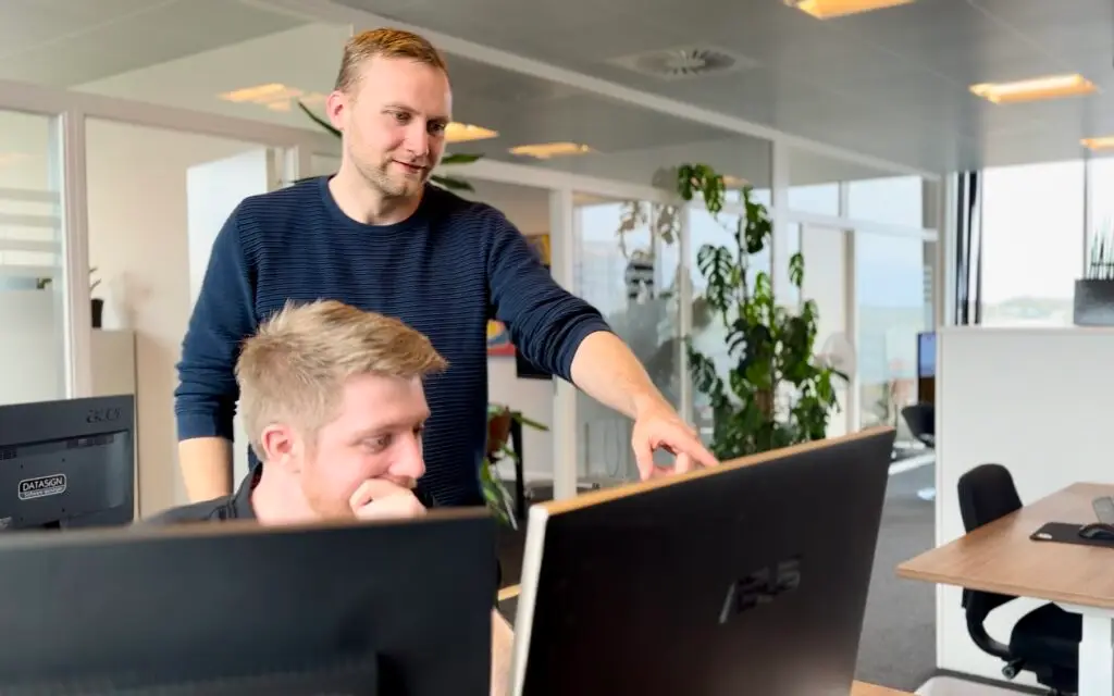 Samarbejde om softwareløsning foran computerskærme